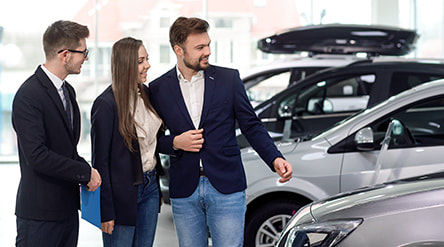 Couple looking a car on the car showroom photo
